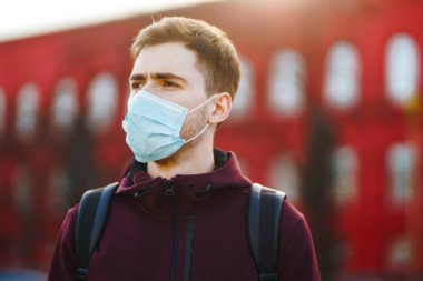 Sokakta yüzünde steril tıbbi maske takan adamların portresi var. Salgının yayılmasını önleme ve koronavirüsü tedavi etme kavramı, karantina şehrinde salgın. Covid 19.