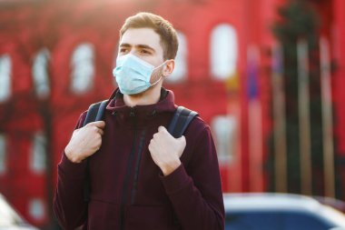 Sokakta yüzünde steril tıbbi maske takan adamların portresi var. Salgının yayılmasını önleme ve koronavirüsü tedavi etme kavramı, karantina şehrinde salgın. Covid 19.