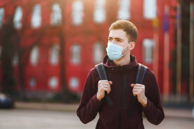 Sokakta yüzünde steril tıbbi maske takan adamların portresi var. Salgının yayılmasını önleme ve koronavirüsü tedavi etme kavramı, karantina şehrinde salgın. Covid 19.