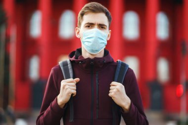 Sokakta yüzünde steril tıbbi maske takan adamların portresi var. Salgının yayılmasını önleme ve koronavirüsü tedavi etme kavramı, karantina şehrinde salgın. Covid 19.