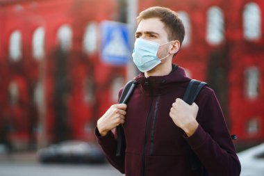 Sokakta yüzünde steril tıbbi maske takan adamların portresi var. Salgının yayılmasını önleme ve koronavirüsü tedavi etme kavramı, karantina şehrinde salgın. Covid 19.
