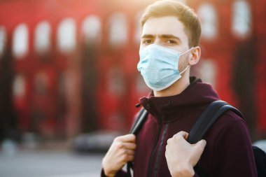 Sokakta yüzünde steril tıbbi maske takan adamların portresi var. Salgının yayılmasını önleme ve koronavirüsü tedavi etme kavramı, karantina şehrinde salgın. Covid 19.