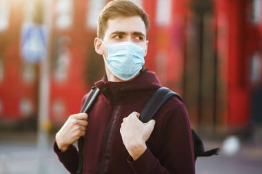 Sokakta yüzünde steril tıbbi maske takan adamların portresi var. Salgının yayılmasını önleme ve koronavirüsü tedavi etme kavramı, karantina şehrinde salgın. Covid 19.