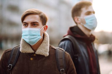 Karantina şehrinde yüzünde steril tıbbi maskeli iki arkadaş vardı. Arkadaşlar, yüz maskesi takın, karantina bölgesinde virüs, salgın ve salgın hastalıklardan korunmak için.. 