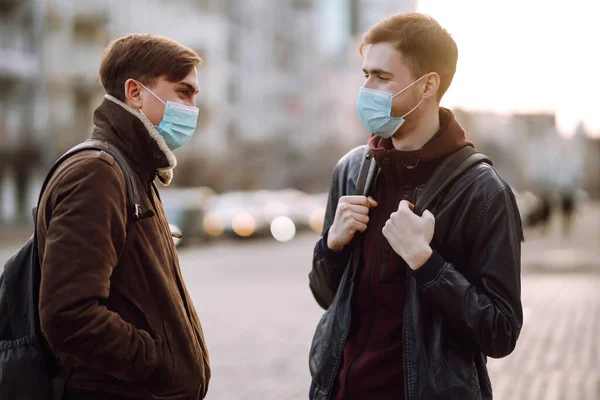 Two Friends in protective sterile medical mask on her face in quarantine city. Friends, wear face mask, protect from infection of virus, pandemic, outbreak and epidemic of disease in quarantine zone.