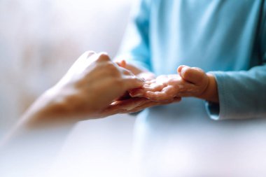 Annem ellerini yıkamasına yardım ediyor. Ellerini birbirine sürterek sabunla köpük oluşturuyorlar. Hijyen konsepti. Mikropların ve bakterilerin yayılmasını önle ve koronavirüsün bulaşmasını önle.