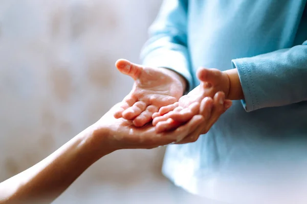 Mom helps her chaild wash her hands. They are rubbing their hands together creating foam with the soap. Hygiene concept. Prevent spread of germs and bacteria and avoid infections coronavirus.