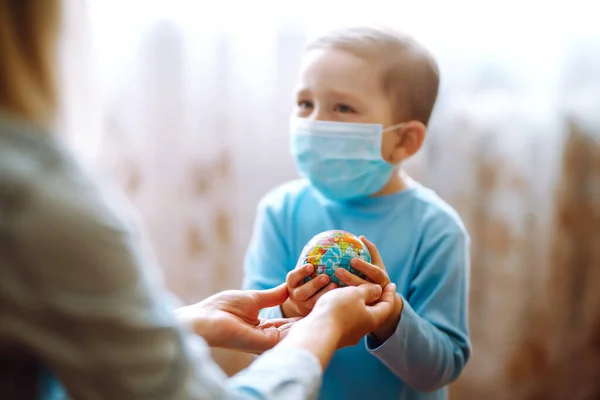 世界を保持する母親と保護滅菌医療マスクの子供 地球を救え 流行性コロナウイルスの拡散を防止する概念 — ストック写真