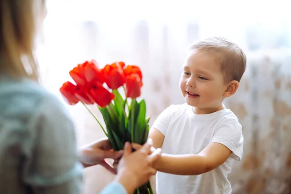 Lilla Sonen Gratulerar Mor Och Ger Bukett Blommor Tulpaner Glad — Stockfoto