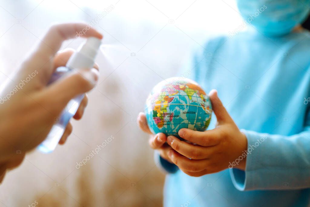 Planet sterilization. Child in protective sterile medical mask holding a world globe. Save planet. The concept of preventing the spread of the epidemic coronavirus.