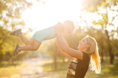 Mutlu anne bebeği kusar, güler ve doğada oynar. Anneler Günün kutlu olsun. Aile tatili ve birliktelik.