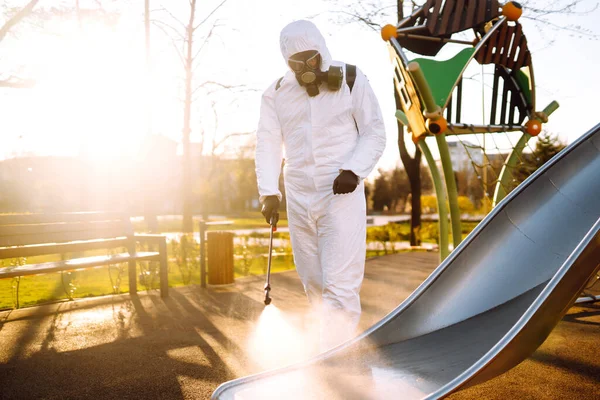 Homem Vestindo Roupa Protetora Desinfetando Playground Sol Com Produtos Químicos — Fotografia de Stock