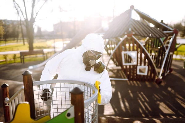 Man wearing protective suit washes and disinfecting the playground to preventing the spread of the epidemic of coronavirus, pandemic in quarantine city. Covid -19. Cleaning and Disinfection.