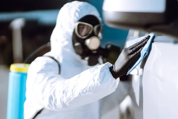 車の保護スーツ洗浄と消毒ハンドルで男の手 コロナウイルスの流行の広がりを防ぐために 検疫都市のパンデミック — ストック写真