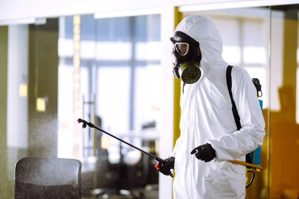 办公室消毒以防止Covid 穿着防护服的男子用喷雾剂化学品 以防止大肠病毒在检疫城市的蔓延 清洗概念 — 图库照片