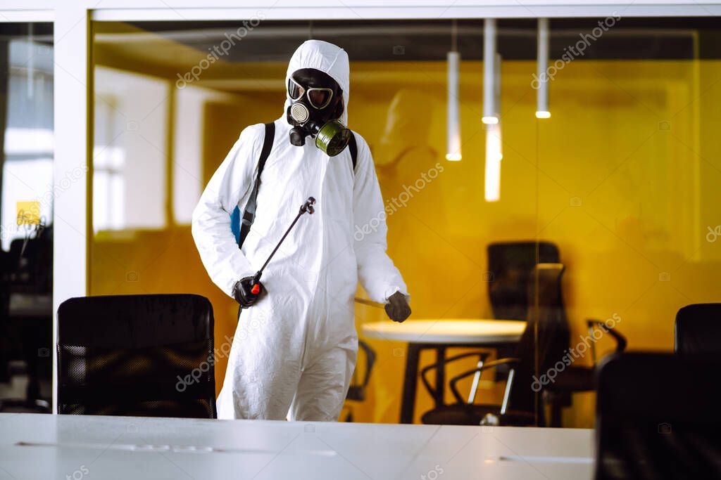 Disinfecting of office to prevent COVID-19, Man in protective hazmat suit with  with spray chemicals to preventing the spread of coronavirus, pandemic in quarantine city. Cleaning concept.