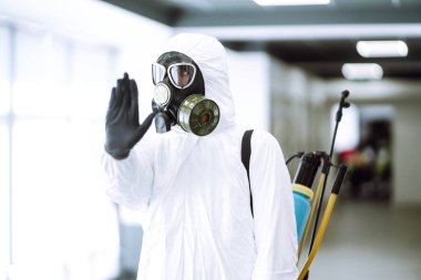 El durdurma işareti. Koruyucu koruyucu koruyucu giysili adam koronavirüs salgınını durdurmak için el hareketi gösteriyor. Salgının yayılmasını önleme kavramı. Covid 19.