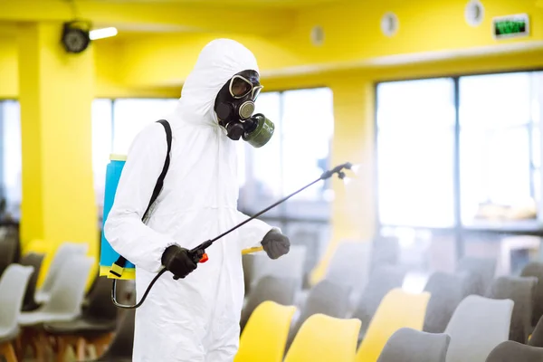 Hombre Con Traje Protector Desinfectando Salón Reunión Con Productos Químicos — Foto de Stock