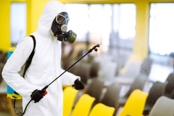 Hombre Con Traje Protector Desinfectando Salón Reunión Con Productos Químicos — Foto de Stock