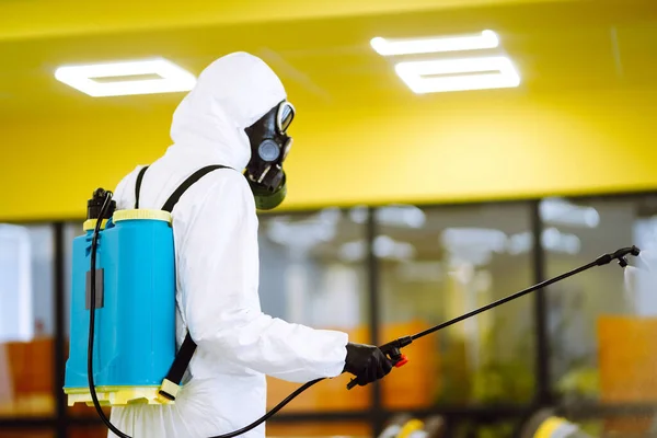 Hombre Con Traje Protector Desinfectando Salón Reunión Con Productos Químicos — Foto de Stock