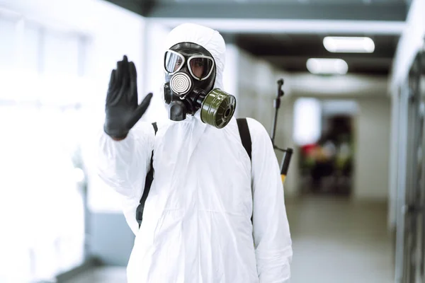 Hand stop sign. Man in protective hazmat suit  shows stop hands gesture for stop coronavirus outbreak. The concept of preventing the spread of the epidemic. Covid-19.