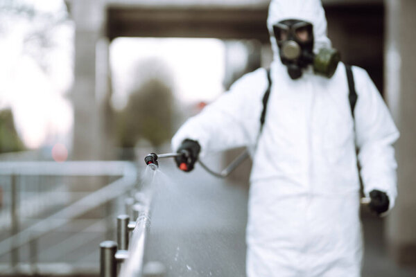 Дезинфекционные опрыскиватели с распылителями химикатов на перила в пустом общественном месте на рассвете в городе карантина. Ковид - 19. Концепция очистки
.