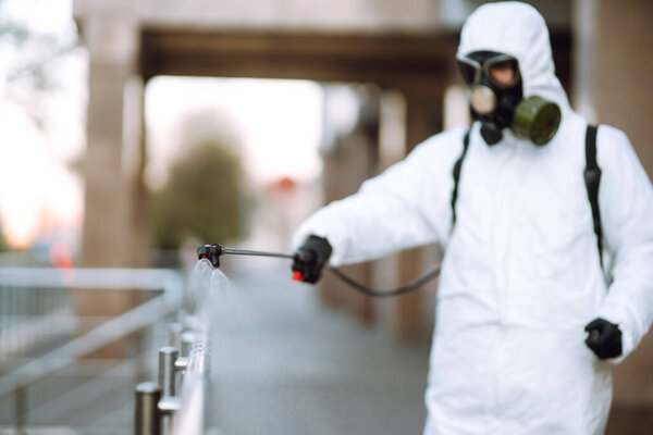 Дезинфекционные опрыскиватели с распылителями химикатов на перила в пустом общественном месте на рассвете в городе карантина. Ковид - 19. Концепция очистки
.