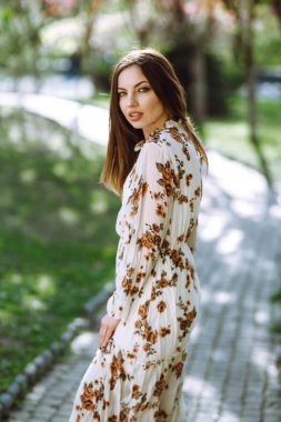 Çiçek açan bahar ağacının yanında güzel genç bir kadın. Parkta eğlenen çekici bir kız. Bahar geldi..