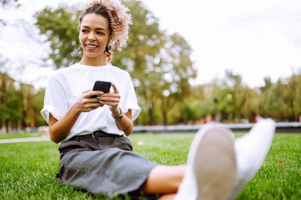 Jovem Mulher Sentada Grama Parque Cidade Usando Smartphone Tecnologia Conceito — Fotografia de Stock