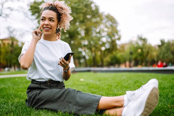 Młoda Kobieta Siedząca Trawie Parku Miejskim Używająca Smartfona Technologia Koncepcja — Zdjęcie stockowe