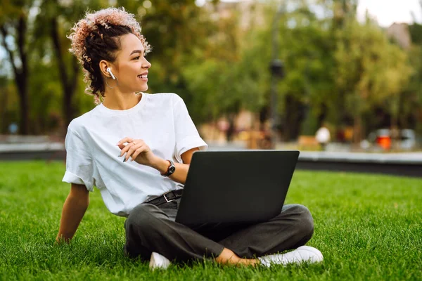 Mujer Con Auriculares Sentados Hierba Parque Trabajando Portátil Concepto Trabajo —  Fotos de Stock