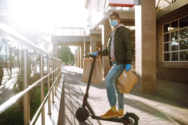 医療用マスクと手袋の宅配便は 隔離された都市の食品の袋をスクーターで提供します 配達サービスの概念 Covid 2019 — ストック写真