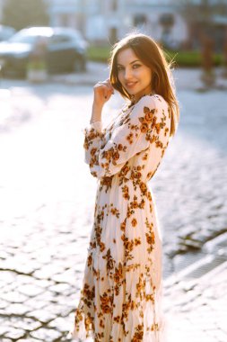 Gün batımında şehirde yaz kızı. İnsanlar, özgürlük, yaşam tarzı, seyahat ve tatil kavramı.