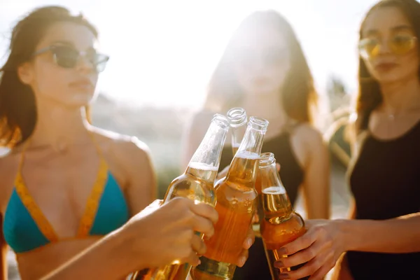 Szczupłe Dziewczyny Wiwatują Piją Piwo Plaży Zachodzie Słońca Młoda Czwórka — Zdjęcie stockowe