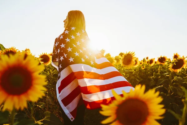 7月4日在向日葵地里挂着美国国旗的好姑娘 夕阳西下独立日 爱国观念 — 图库照片