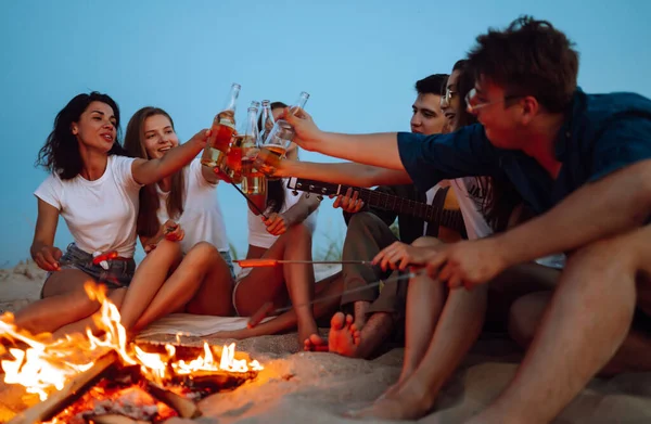 Gruppo Amici Vicino Falò Sulla Spiaggia Acclamano Bevono Birra Notte — Foto Stock
