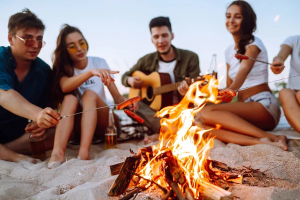 Groep Jonge Vrienden Die Het Strand Zitten Worstjes Bakken Eén — Stockfoto