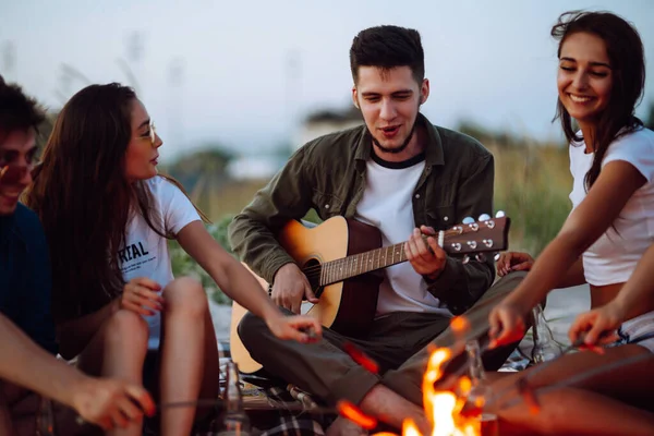 Group Young Friends Sitting Beach Fry Sausages One Man Playing — Stock Photo, Image