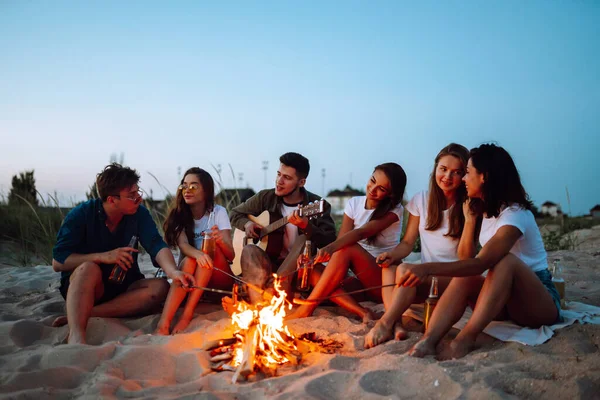 Gruppo Giovani Amici Seduti Sulla Spiaggia Friggere Salsicce Uomo Sta — Foto Stock