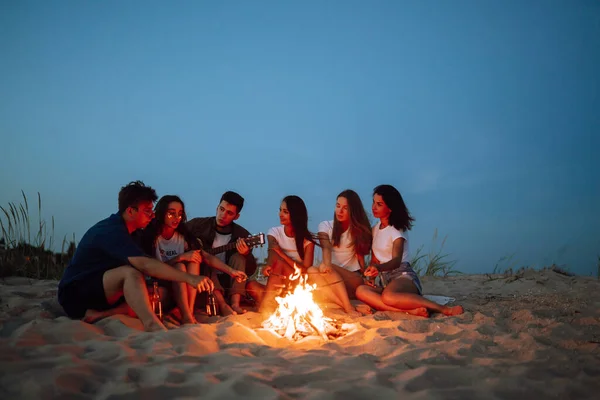 Group Young Friends Sitting Beach Fry Sausages One Man Playing — Stock Photo, Image