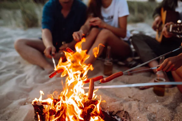 Fried Sausages Bonfire Group Young Friends Sitting Beach Fry Sausages — Stock Photo, Image