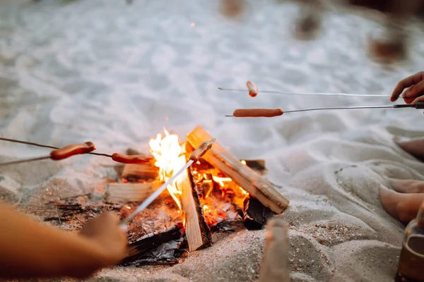 Salsicce Fritte Falò Gruppo Giovani Amici Seduti Sulla Spiaggia Friggere — Foto Stock