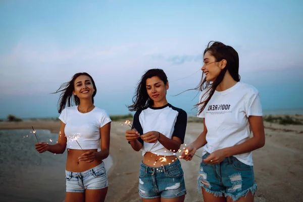 Tre Belle Ragazze Che Festeggiano Tenendo Scintille Sulla Spiaggia Notte — Foto Stock