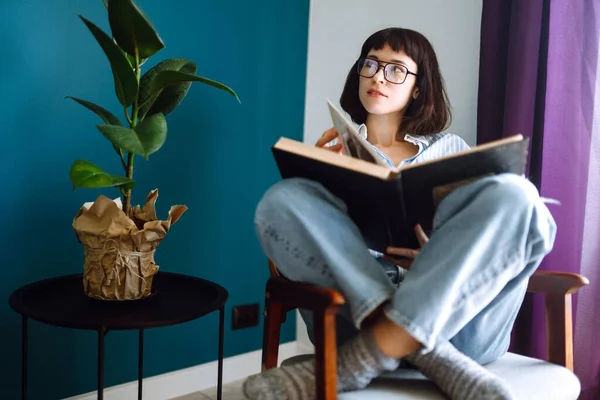 Uma Jovem Livro Casa Sentada Uma Cadeira Moderna Relaxa Sua — Fotografia de Stock