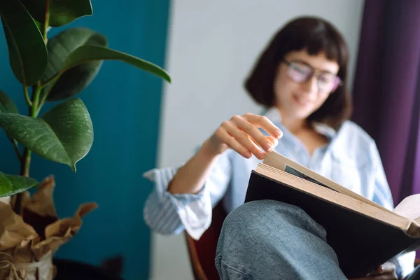 Young Woman Reads Book Home Sitting Modern Chair Relaxes Her — Stock Photo, Image