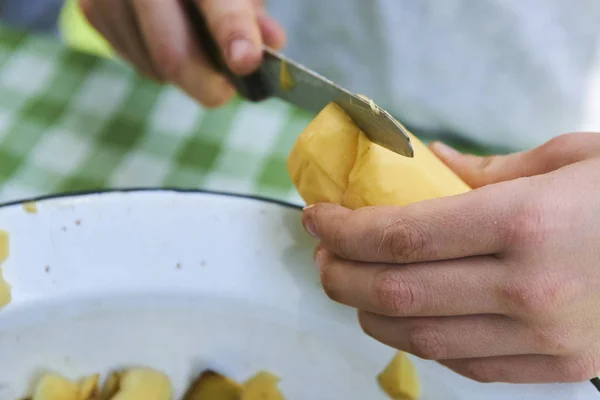 Detalle de las manos de los niños pelando papas amarillas frescas con cuchillo de cocina . — Foto de Stock