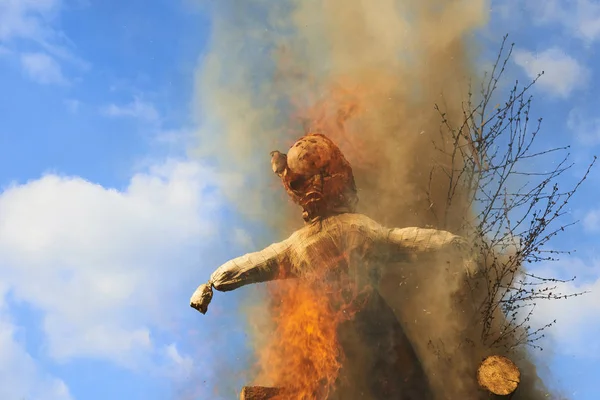 burning dummy, blazing orange red flame of fire against blue day sky  