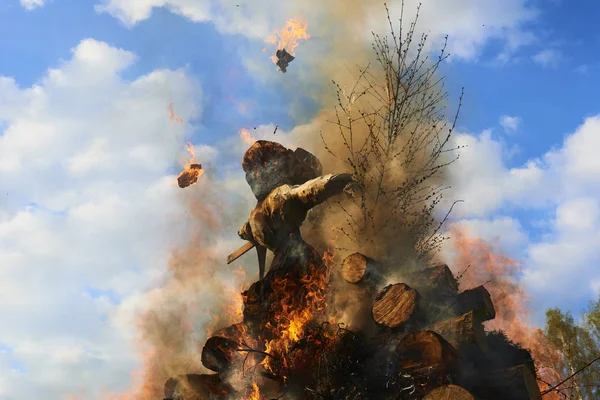 burning dummy, blazing orange red flame of fire against blue day sky  
