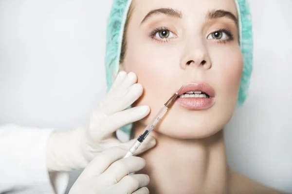 Doctor aesthetician makes lips correction and augmentation to female patient — Stock Photo, Image