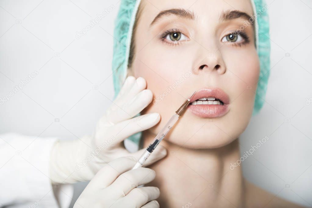 Doctor aesthetician makes lips correction and augmentation to female patient